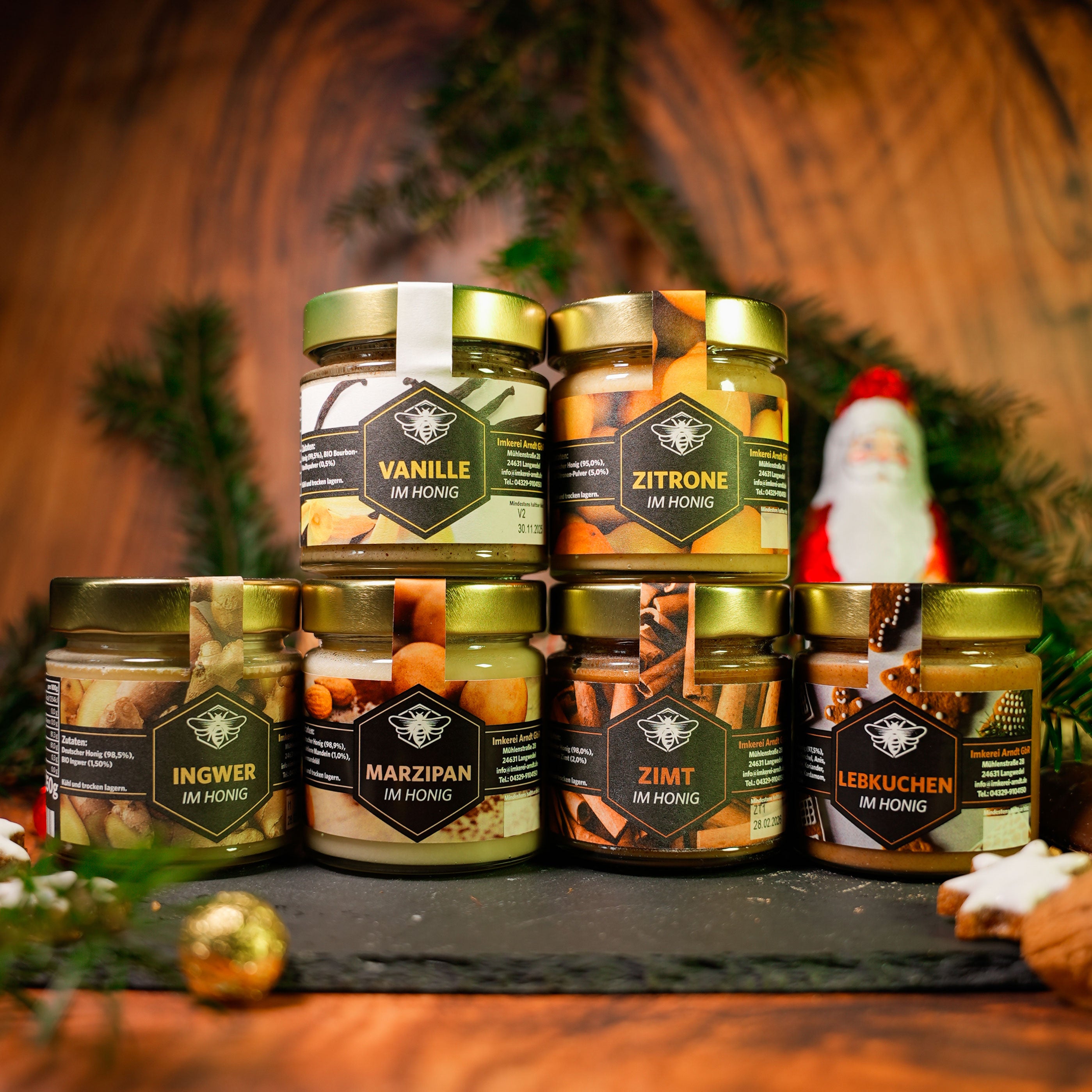 Auf dem Produktfoto sind sechs Gläser mit Honig abgebildet, die als Set erworben werden können. (Vanille im Honig, Lebkuchen im Honig, Marzipan im Honig, Zitrone im Honig, Ingwer im Honig und Zimt im Honig)