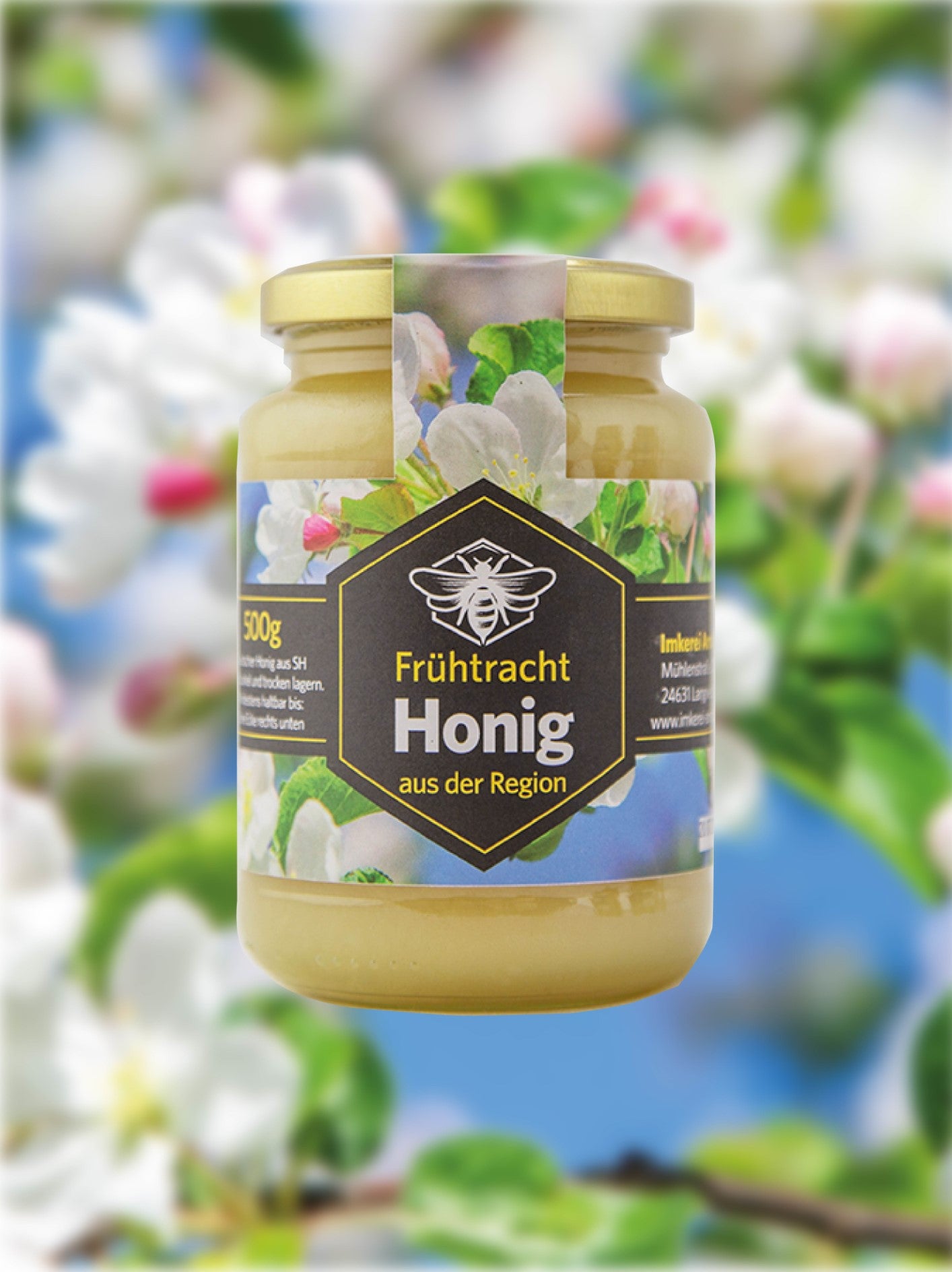 Abgebildet ist ein Glas Frühtrachthonig. Im Hintergrund ist ein blühender Baum zu sehen.